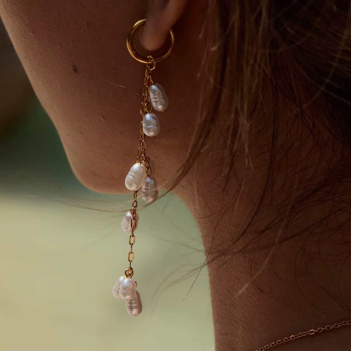 ALIÉA Lilly kædeøreringe i 18K forgyldt stål med hvide perler, der hænger elegant fra øret.