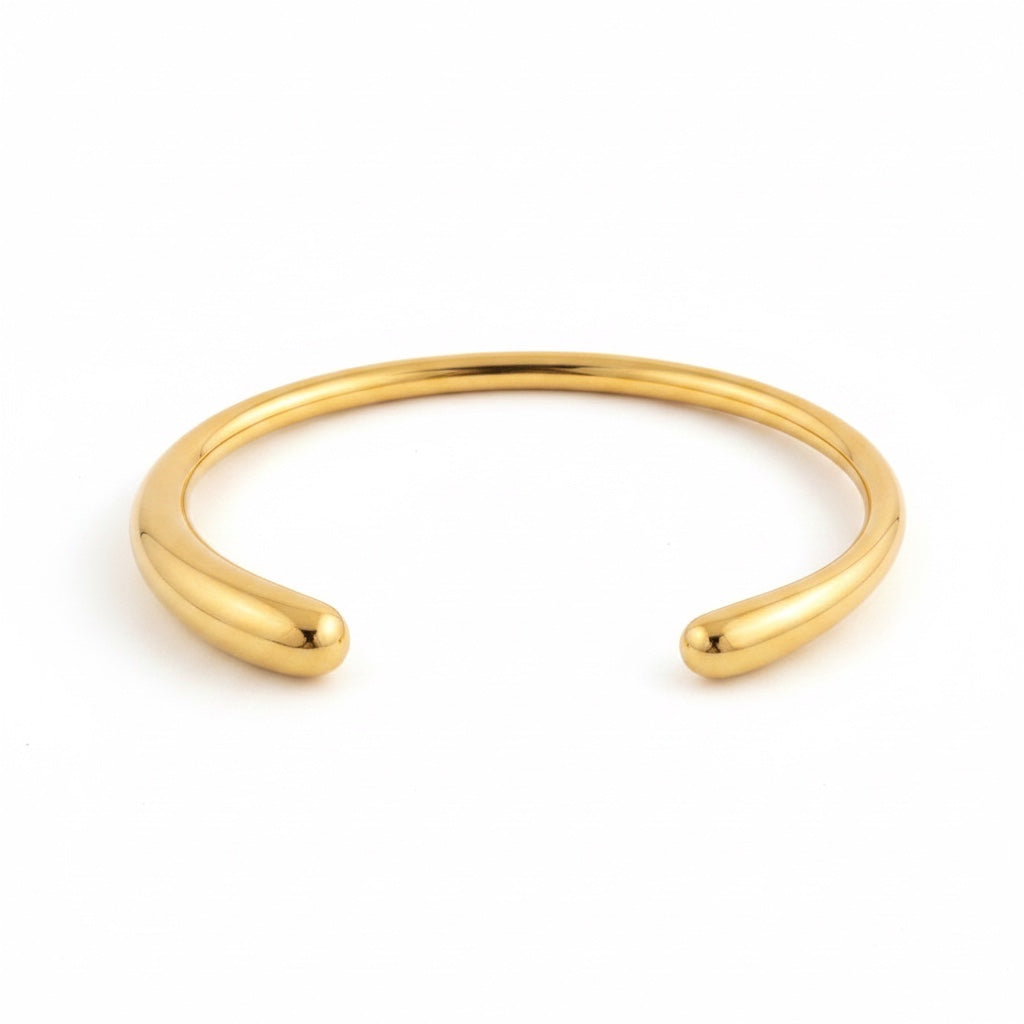 ALIÉA Sienna cuff-armbånd i 18K guldbelagt rustfrit stål med et minimalistisk og åbent design.