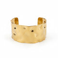ALIÉA Valentina cuff-armbånd i guldbelagt rustfrit stål med en elegant, hamret organisk overflade.