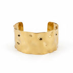 ALIÉA Valentina cuff-armbånd i guldbelagt rustfrit stål med en elegant, hamret organisk overflade.